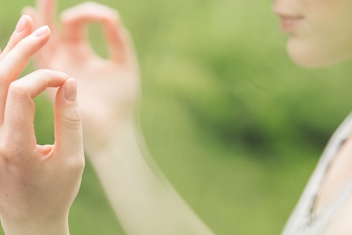 Femme méditant en plein air, mains en mudra.